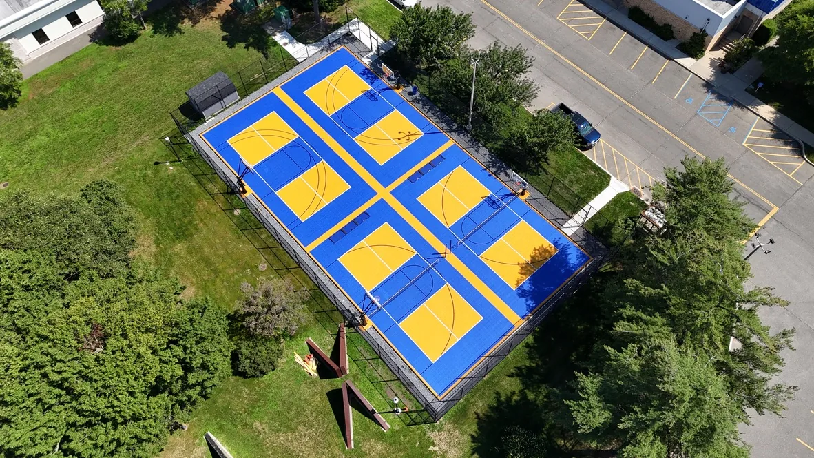 Blue and yellow court divided into four basketball half courts