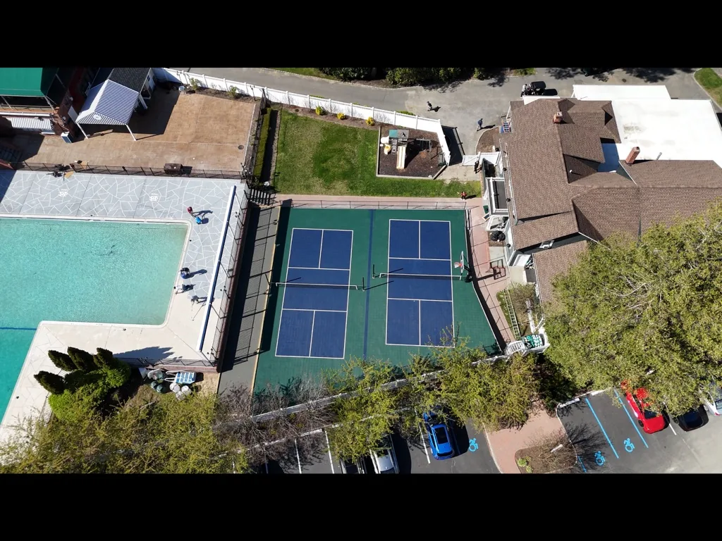 Two pickleball courts beside a swimming pool at a club