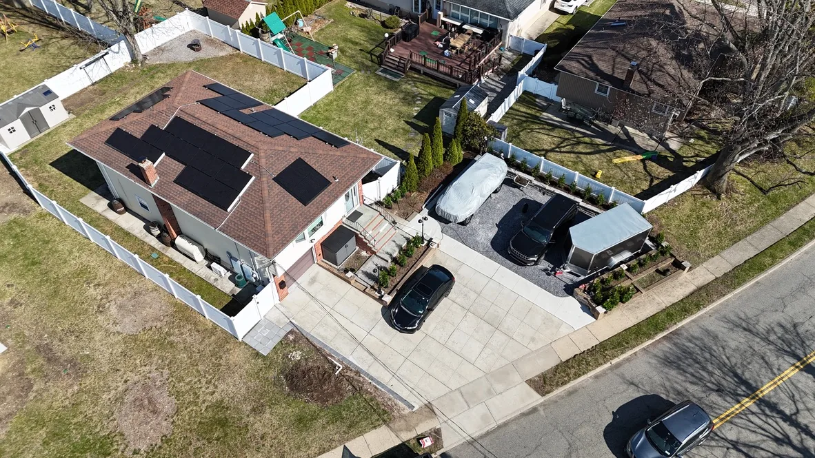 Aerial view after the driveway was widened and extended into a parking apron, with a gravel bed and new planting along the edge