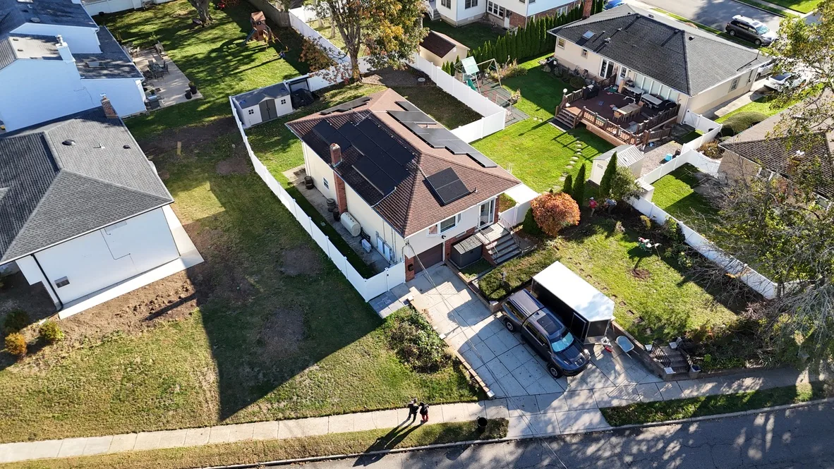Aerial view of the property before the work, with a single width concrete driveway and lawn on either side